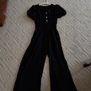 Medium Black wide leg jumpsuit with pockets, perfect for holiday wear.